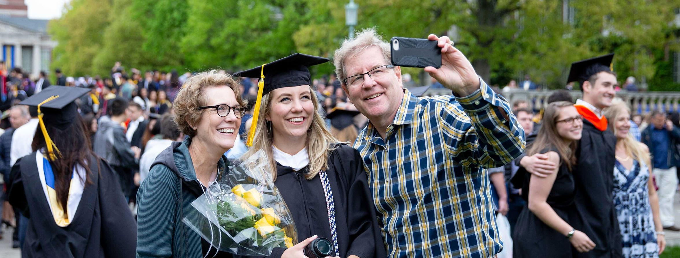 Student poses for photo with their relatives at University of Rochester